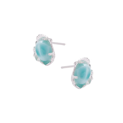 Oval larimar gemstone studs with ornate silver settings showing natural turquoise marbling on cream background