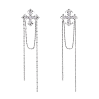 White gold plated baroque cross stud earrings with long cascading zirconia chains on cream background