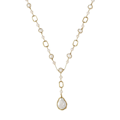 Y-shaped gold necklace with alternating geometric links, freshwater pearls, and baroque pearl pendant on cream background