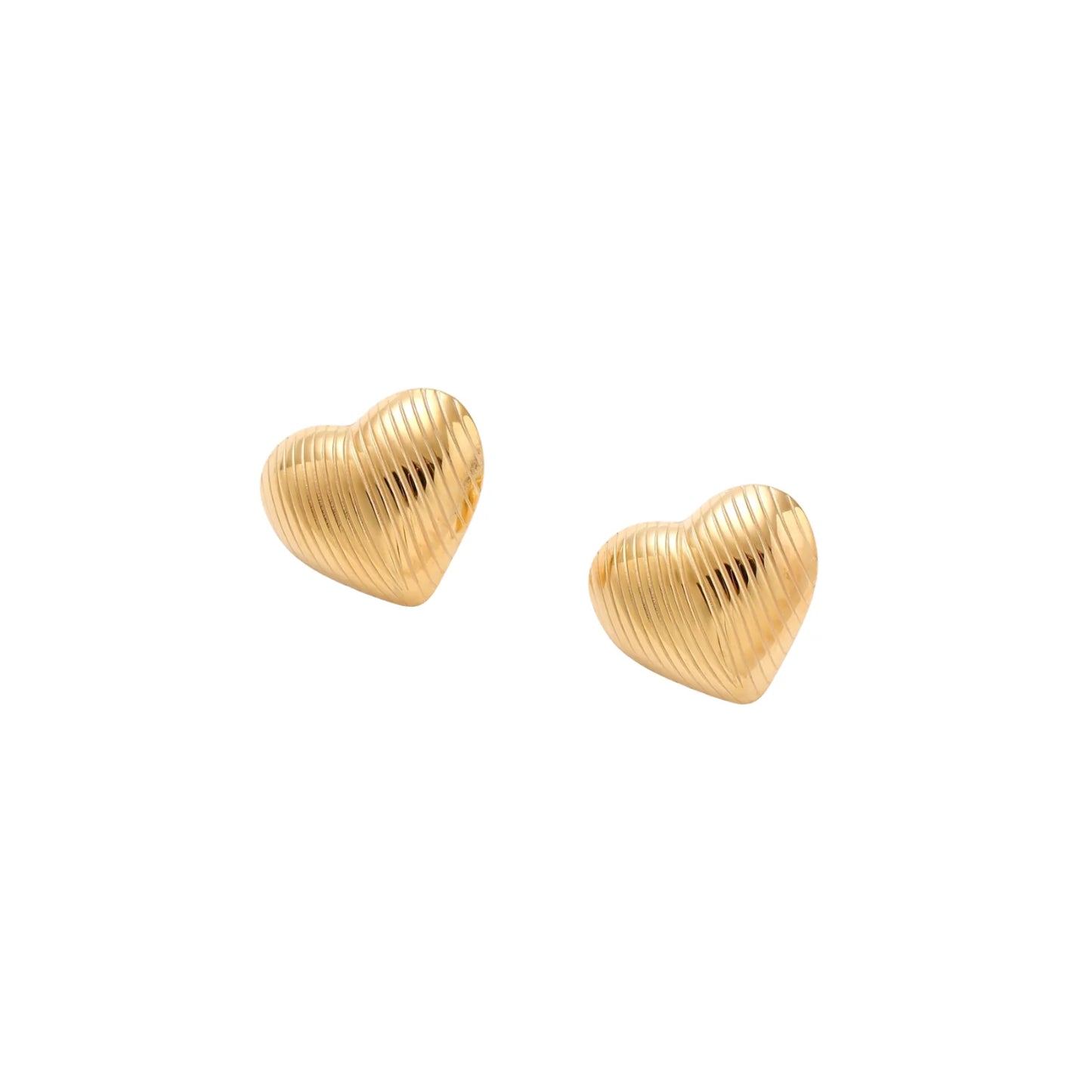 Gold heart-shaped stud earrings with parallel ridged texture on cream background
