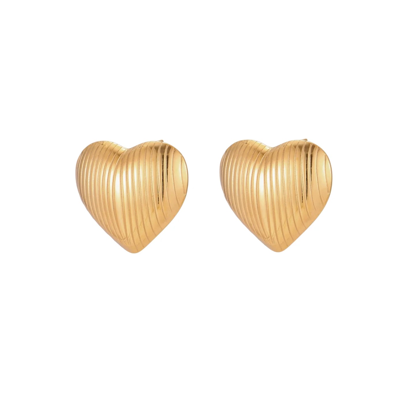 Gold heart-shaped stud earrings with parallel ridged texture on cream background