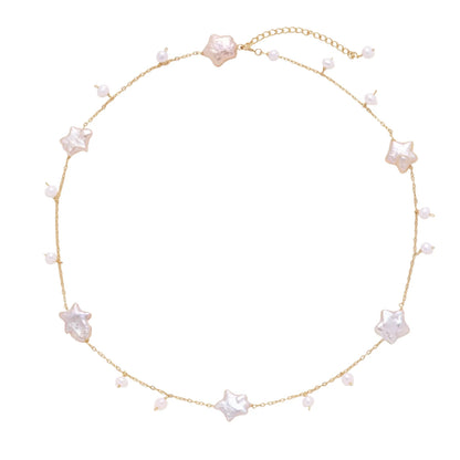 Gold vermeil chain with iridescent star-shaped baroque pearls and small round freshwater pearl drops on cream background.