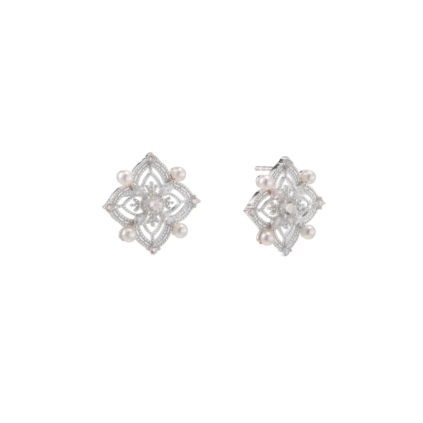 Ornate sterling silver stud earrings with mandala-inspired filigree pattern and four freshwater pearls on beige background
