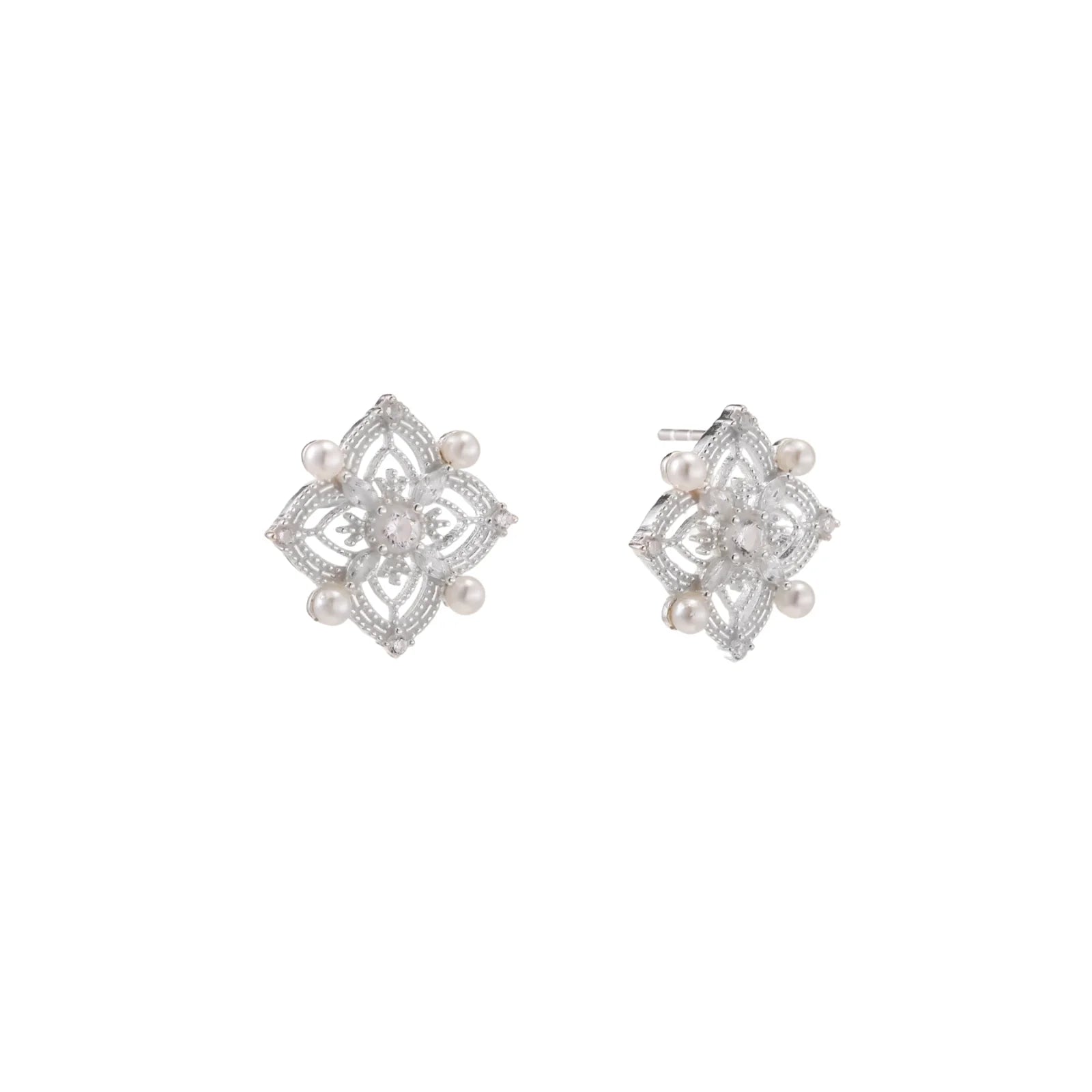 Ornate sterling silver stud earrings with mandala-inspired filigree pattern and four freshwater pearls on beige background
