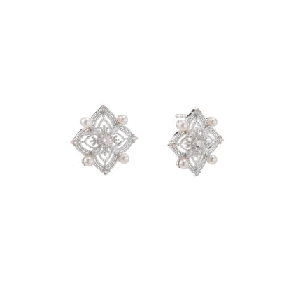 Ornate sterling silver stud earrings with mandala-inspired filigree pattern and four freshwater pearls on beige background