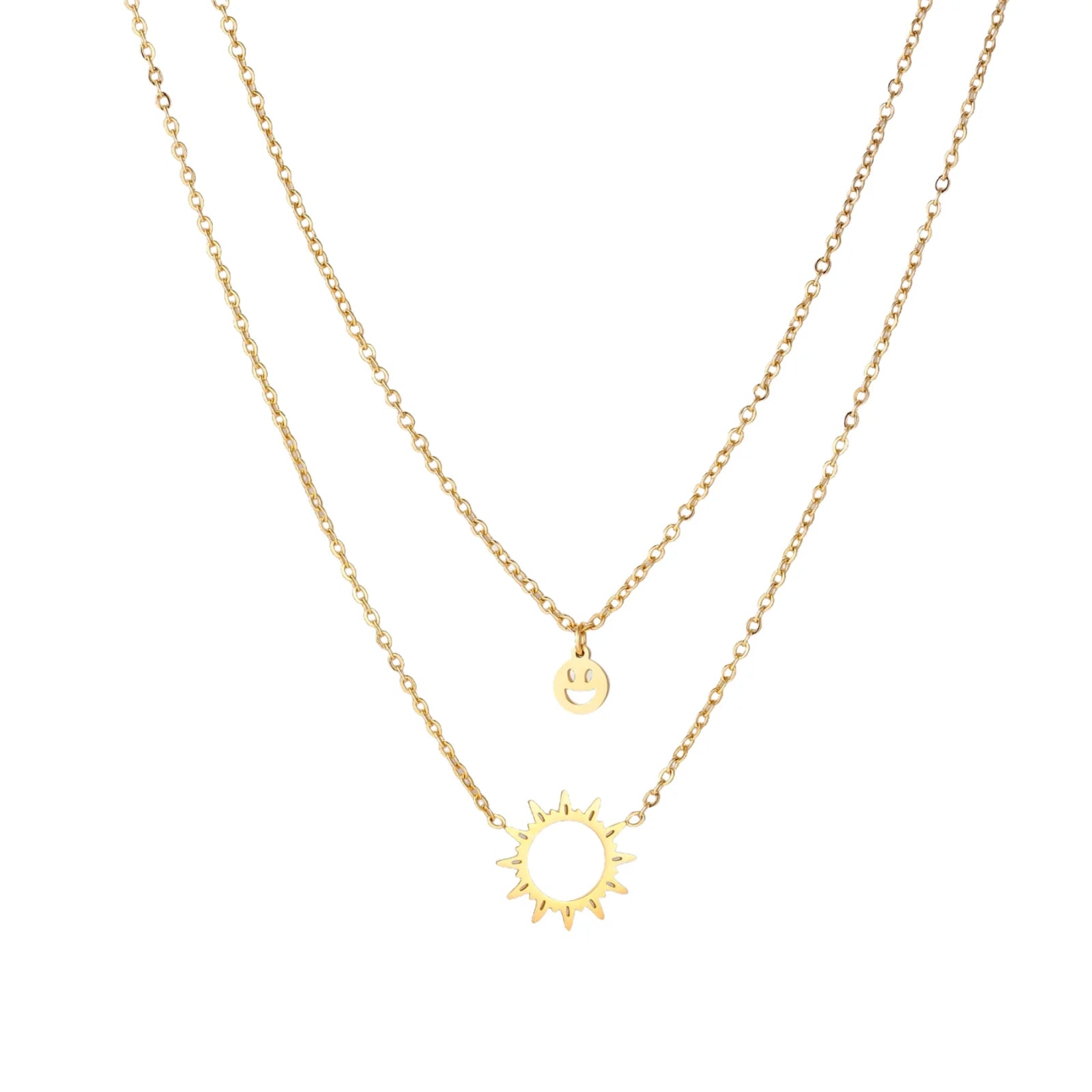 Gold layered necklace set with sunburst and smiley face pendants on delicate chains against white background.