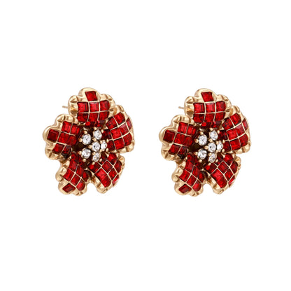 Gold-plated flower studs with burgundy square crystals in petal mosaic and clear center stones on beige background.