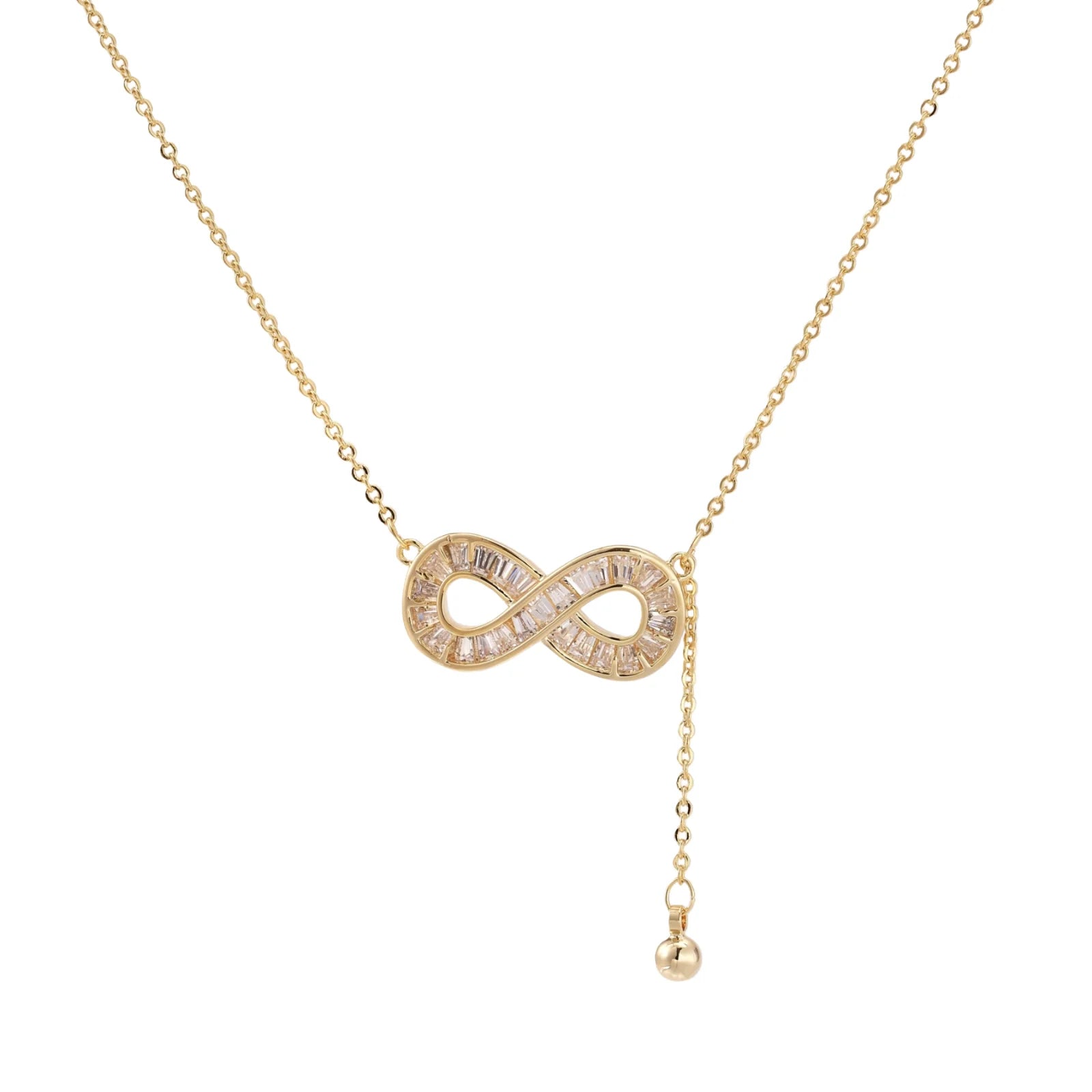 Gold infinity pendant with baguette crystals on adjustable chain against cream background.