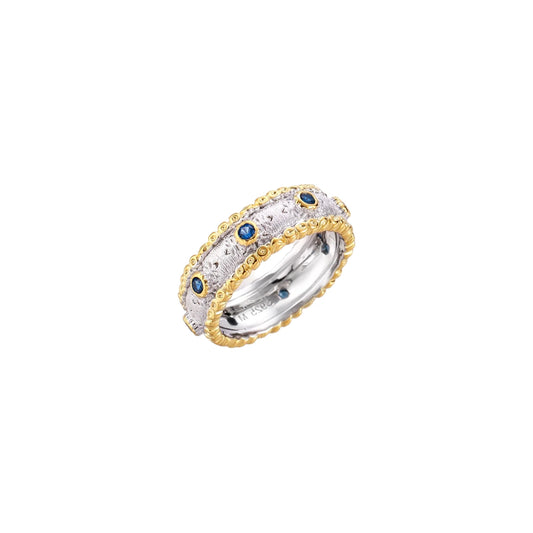 Two-tone ring with brushed silver center, gold beaded edges, and blue zirconia stones on white background.