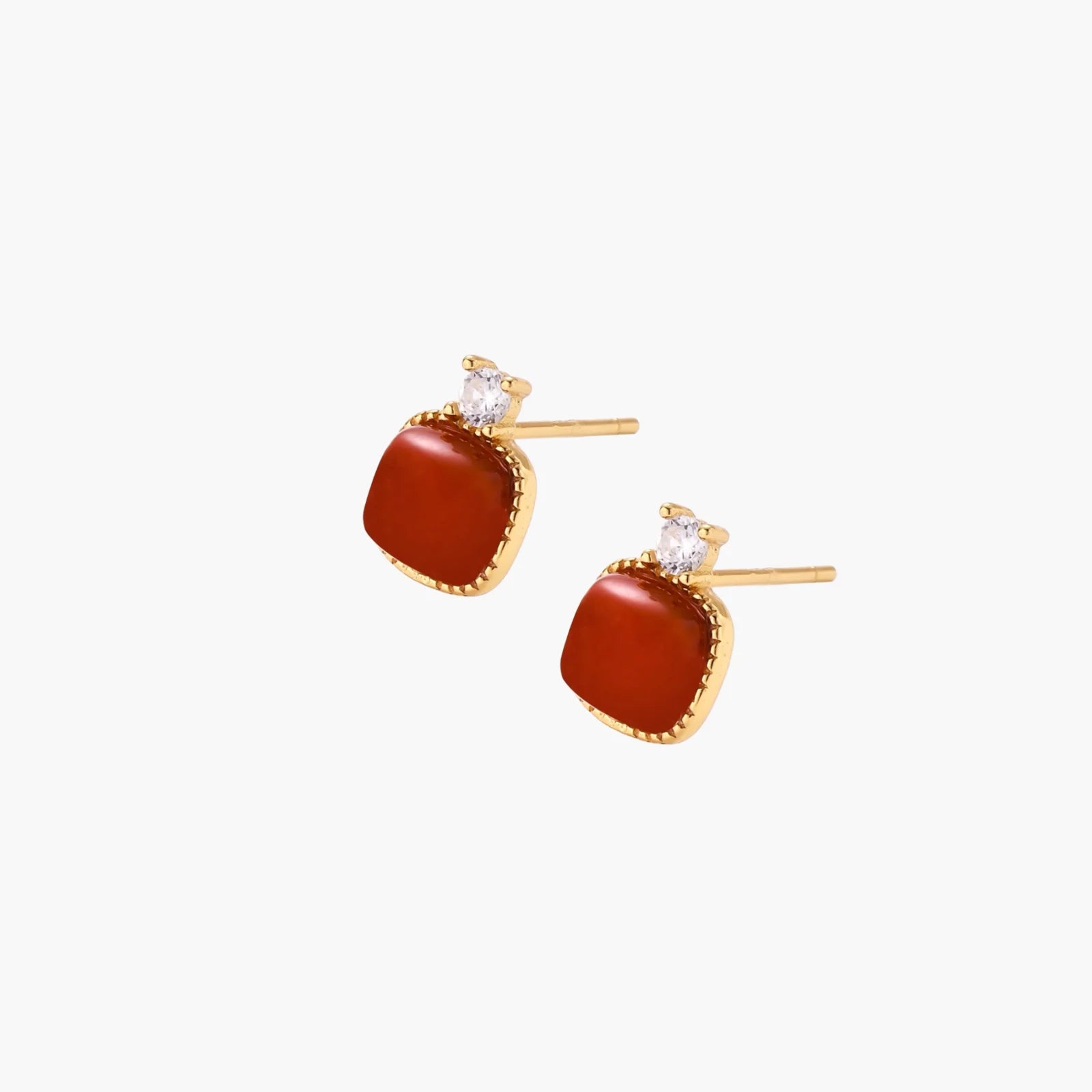 18K gold vermeil stud earrings with cushion-cut red agate stones and sparkling crystal accents on beige background