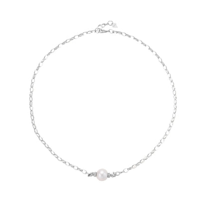 Dainty rhodium-plated silver chain necklace with centered 10mm freshwater pearl and crystal accents on cream background