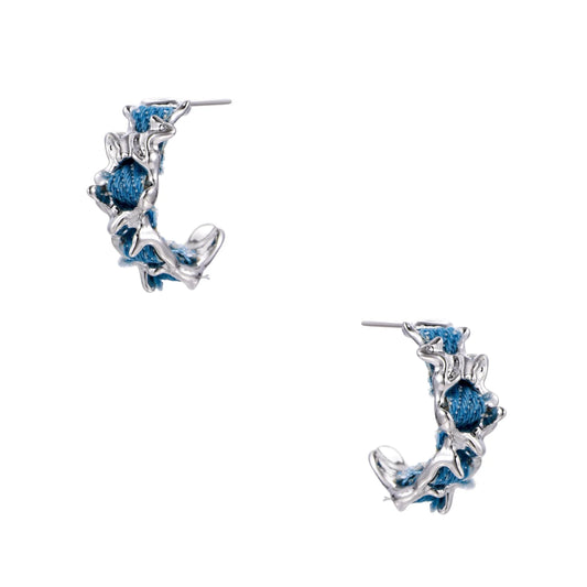 White gold plated hoop earrings with woven blue denim fabric through organic branch-like metal framework