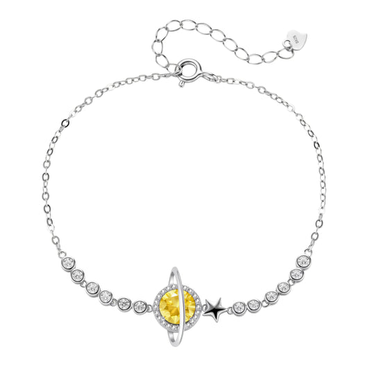 Sterling silver bracelet with yellow moissanite centerpiece in oval setting, crystal chain, and star charm on white background.